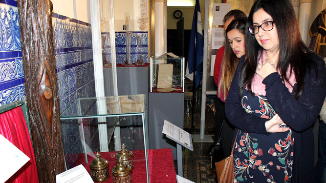 Una mujer observa algunas piezas de la muestra, en el Casino Español de Bollullos Par del Condado.