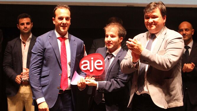 David Muñoz, gerente de Neobotik, recoge el premio de manos del presidente de AJE Huelva, Miguel Borrero, y del alcalde de Huelva, Gabriel Cruz.