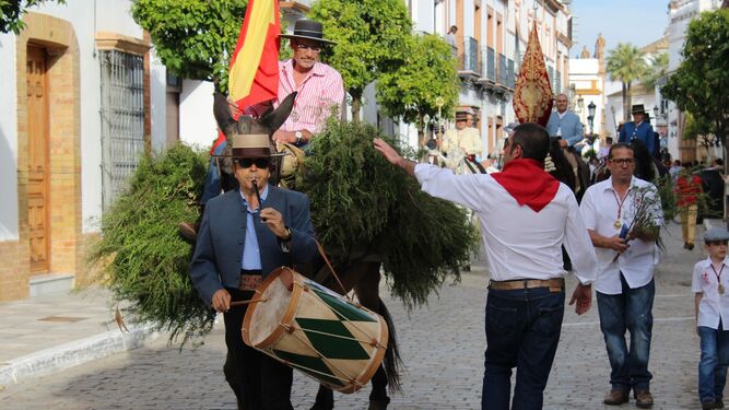 Un momento del recorrido procesional de la Cruz de la calle Sevilla por La Palma del Condado.