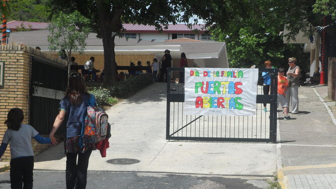 Una madre con su pequeña se dirige hacia la entrada del colegio José Nogales.