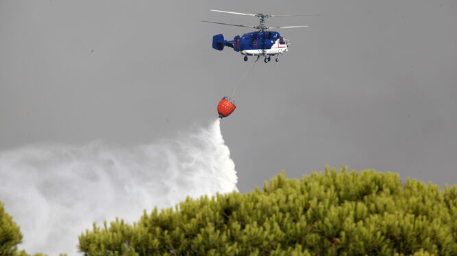 Un helicóptero trabaja en la extinción del incendio de Gibraleón.