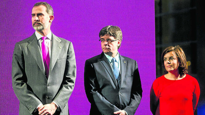 El rey Felipe, Puigdemont y Sáenz de Santamaría en un acto en un despacho de abogados de Barcelona en febrero.