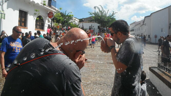 Dos hombres se echan agua en la fiesta de Los Jarritos en Galaroza.