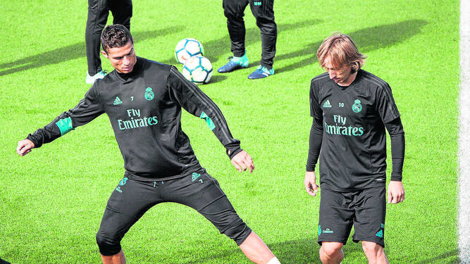Cristiano, ausente de la convocatoria por sanción, intenta arrebatarle el balón a Modric en el entrenamiento.