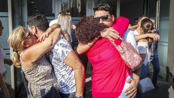 Los familiares abrazan a dos de los acusados a las puertas de los juzgados de Cádiz.