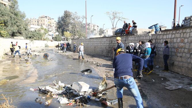 Varias personas realizan tareas de limpieza en un canal, ayer en Damasco.