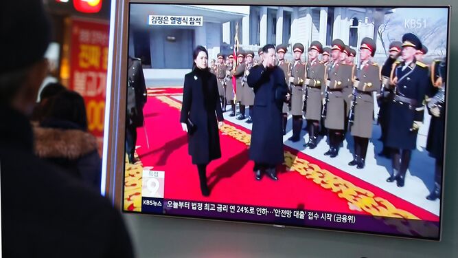 Un hombre sigue por televisión en Seúl el desfile militar norcoreano, al que Kim Jong-un asistió junto a su esposa.