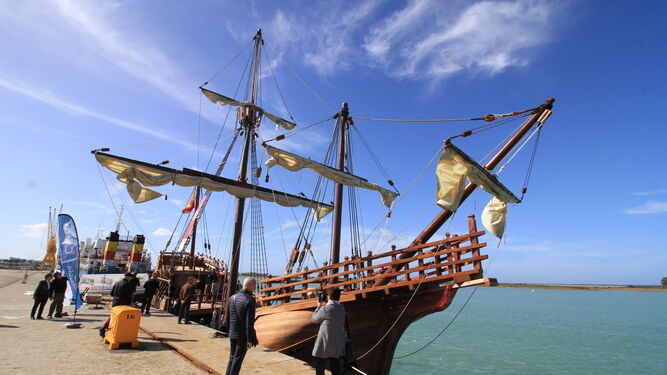 Varios ciudadanos miran y fotografían ayer desde el exterior la réplica de la nao 'Santa María' atracada en el Muelle de Levante, en la capital onubense.