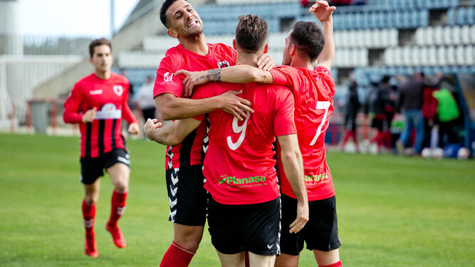 Los jugadores del Cartaya se abrazan tras lograr uno de los goles de la victoria de ayer.