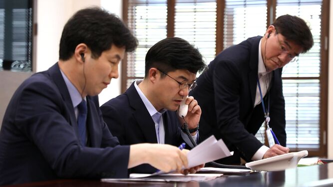 Funcionarios realizan una llamada de prueba a la comisión norcoreana, ayer en la oficina presidencial en Seúl.