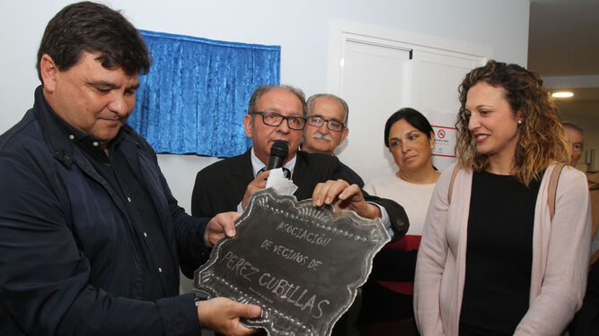 El presidente de la asociación de vecinos entrega una placa al alcalde de la capital.