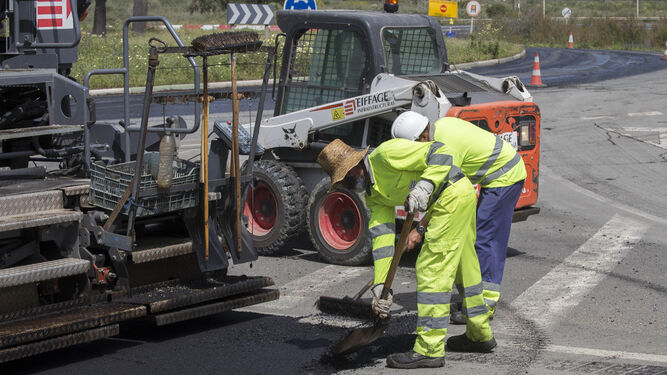 Operarios echan nuevas capas de asfalto en una vía de la ciudad.