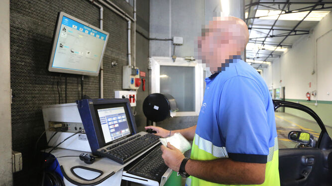 Un trabajador comprueba datos de un coche a través de la pantalla.