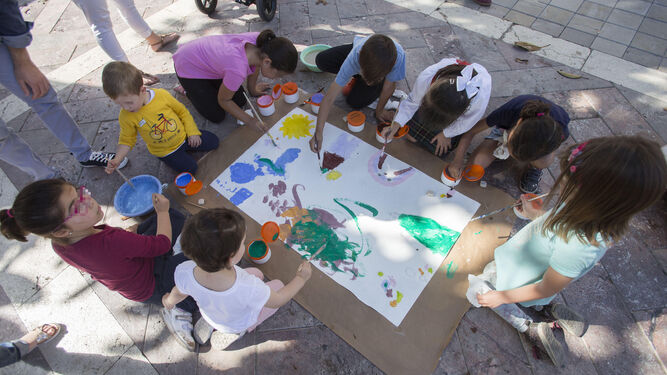 Varios niños pintan un mural en la Plaza de las Monjas para fomentar el 'Derecho a jugar y expresarse libremente'.