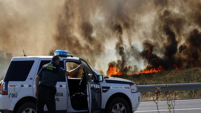 La Guardia Civil corta el tráfico ante la cercanía de las llamas en el incendio del arroyo Pedraza, en Ayamonte, el pasado junio.