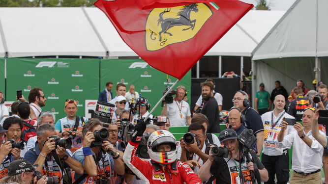 Sebastian Vettel ondea una bandera de Ferrari mientras celebra su victoria.