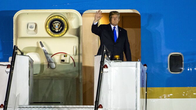 Trump saluda desde el avión al llegar al aeropuerto de Singapur.