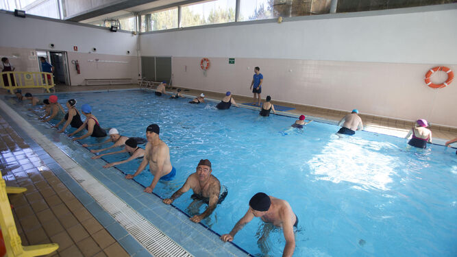 Mayores que participan en la campaña municipal realizan ejercicios en la piscina.