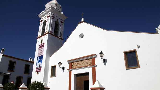 Exterior de la parroquia de San Sebastián, con una gran banderola en su campanario.