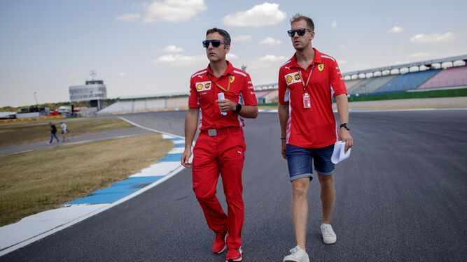 Sebastian Vettel, junto a uno de sus operarios, da una vuelta de reconocimiento al circuito de Hockenheimring.