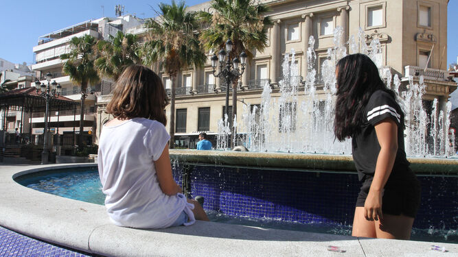 Dos niñas se refrescan un día de calor en la fuente de la Plaza de las Monjas.