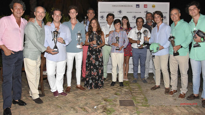 Foto de familia de los ganadores con sus trofeos al concluir la jornada en el campo de golf ayamontino.
