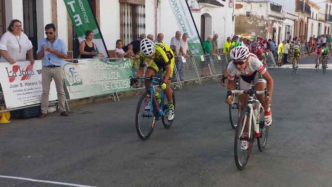 Dos ciclistas esprintan para lograr la victoria en la línea de meta de San Juan del Puerto.