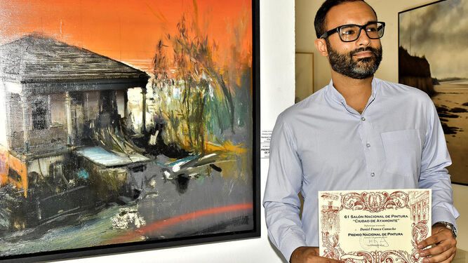 El pintor Daniel Franca posa con su diploma acreditativo del premio delante de su cuadro ganador.