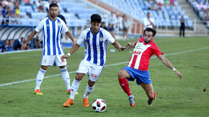 Carlos Martínez intenta zafarse de un jugador del Don Benito en el encuentro de la primera jornada.