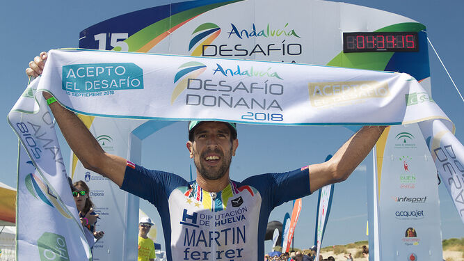 Emilio Martín alza los brazos tras cruzar en primera posición la línea de meta situada en Sanlúcar de Barrameda.