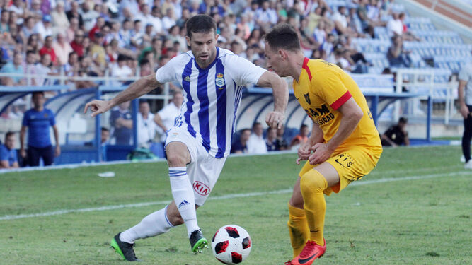 Carlos Martínez se lleva la pelota ante la oposición de un defensor del UCAM Murcia en la primera mitad del encuentro celebrado ayer en el Nuevo Colombino.