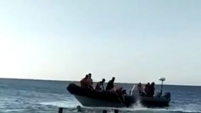 Varios migrantes en torno a una semirrígida junto a las costas de Tarifa.