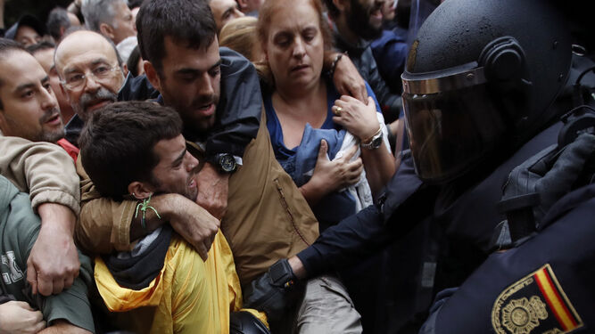 Agentes antidisturbios de la Policía Nacional forman un cordón de seguridad en los alrededores del colegio Ramón Llull de Barcelona el 1-O.