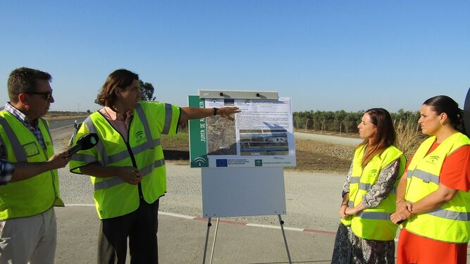 La alcaldesa de Almonte, Rocío Espinosa, atiende las explicaciones del técnico sobre las obras en la carretera.