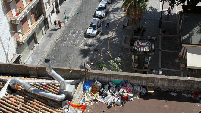 Bolsas con basura y objetos recogidos de las calles se acumulan en la cubierta del edificio número 1 de la calle Méndez Núñez, que hace esquina con la Plaza de las Monjas.