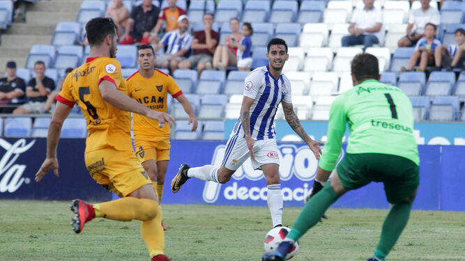 Pablo Andrade, rodeado de jugadores del UCAM, en el encuentro disputado en Huelva entre ambos equipos.