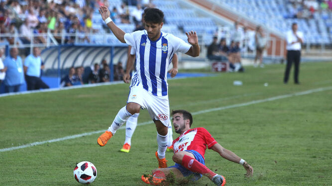 Carlos Martínez supera a un futbolista del Don Benito en el partido disputado en el Nuevo Colombino.