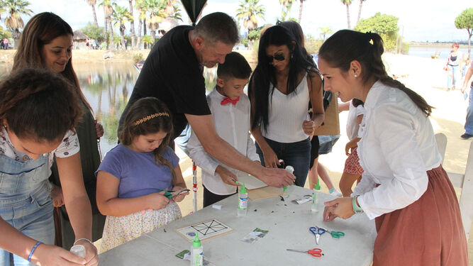 Niños participan en los talleres de elaboración del juego 'Tres en Raya del Encuentro' y de carteles con nombres.