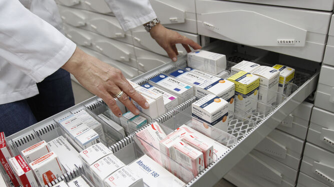Un farmacéutico selecciona un medicamento en el almacén de la farmacia.