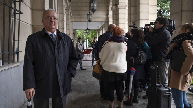 El ex consejero de Empleo Antonio Fernández aguarda mientras su abogado, Alfonso Martínez del Hoyo, atiende a los periodistas.