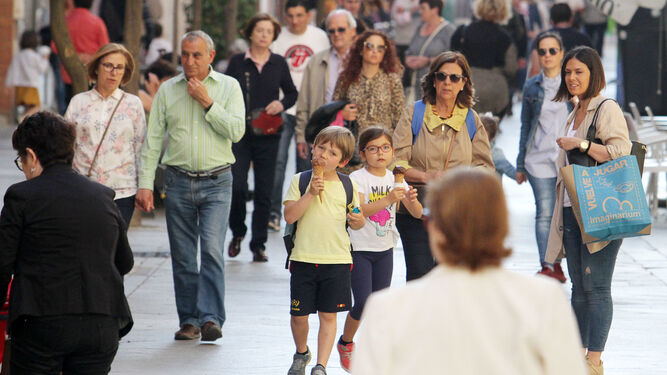 Ciudadanos de diferentes edades transitan por la principal arteria comercial de Huelva.