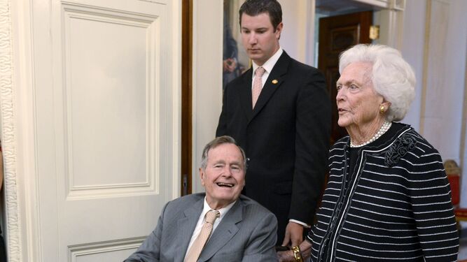 Bush, en silla de ruedas, al lado de su mujer Barbara