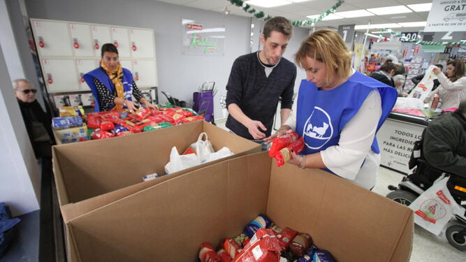Una voluntaria ordena la donación del cliente de un supermercado.