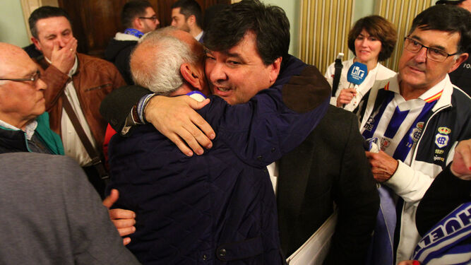 Gabriel Cruz, alcalde de Huelva, se abraza con un aficionado tras la celebración del Pleno, ayer