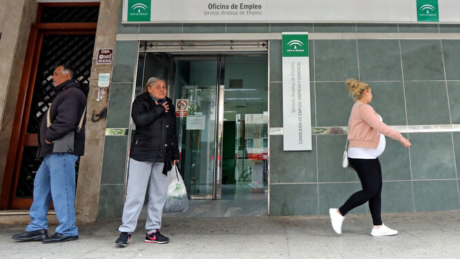 Varias personas en el exterior de una oficina del Servicio Andaluz de Empleo.
