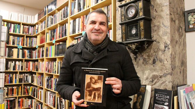 El escritor Manuel Jesús Soriano Pinzón posa en su librería con un ejemplar de su última novela.