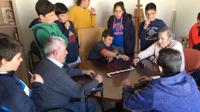 Un niño juega al dominó con los mayores.
