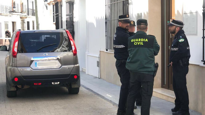 Agentes de la Policía Local y de la Guardia Civil, custodiando la vivienda de la calle Delgado Hernández de Bollullos esta mañana.