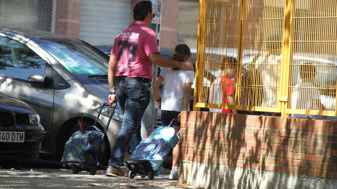 Un padre acompaña a los niños al salir del colegio.