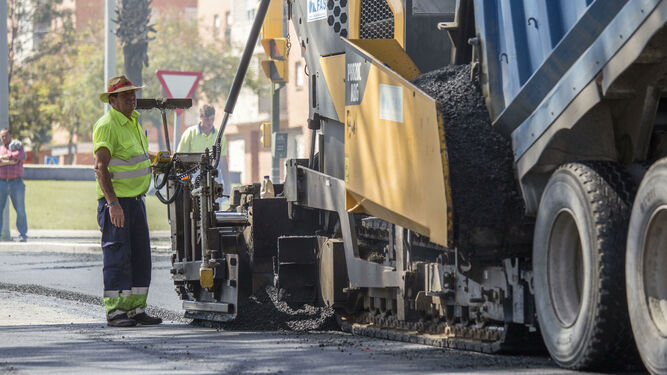Operarios en los trabajos de asfaltado en una avenida de Huelva.